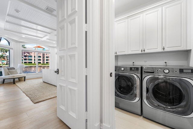 laundry room with light hardwood / wood-style floors, cabinets, and separate washer and dryer