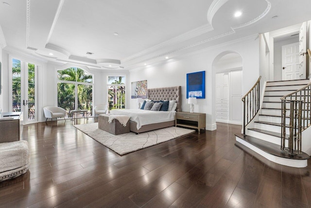 bedroom with a tray ceiling, dark hardwood / wood-style floors, and crown molding