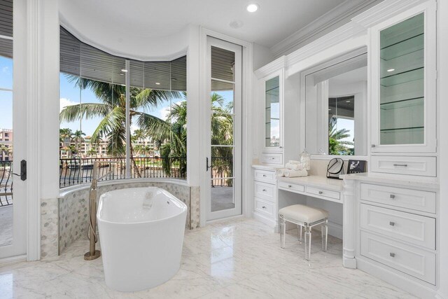 bathroom featuring vanity, a tub, and a wealth of natural light