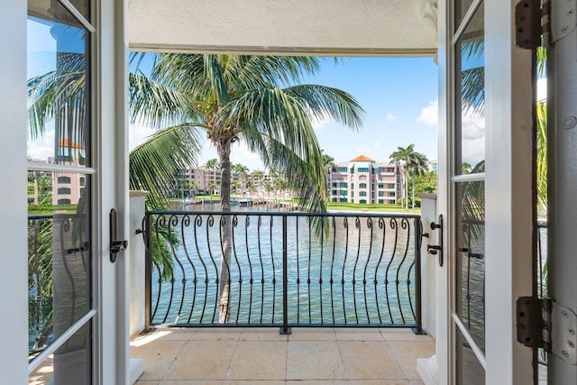 balcony featuring french doors and a water view