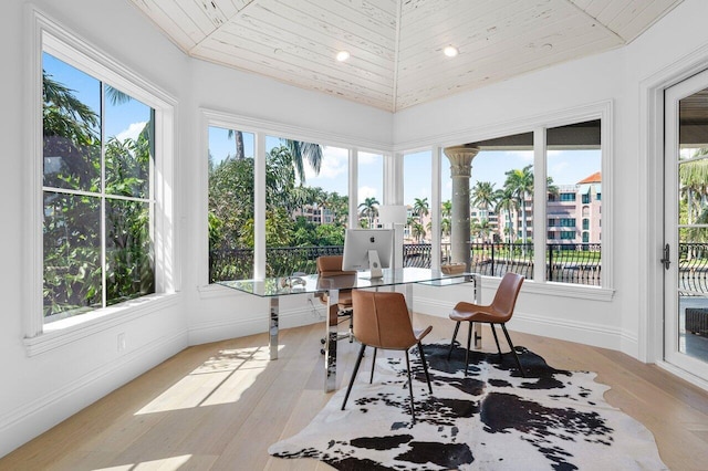 sunroom with vaulted ceiling, a wealth of natural light, and wooden ceiling