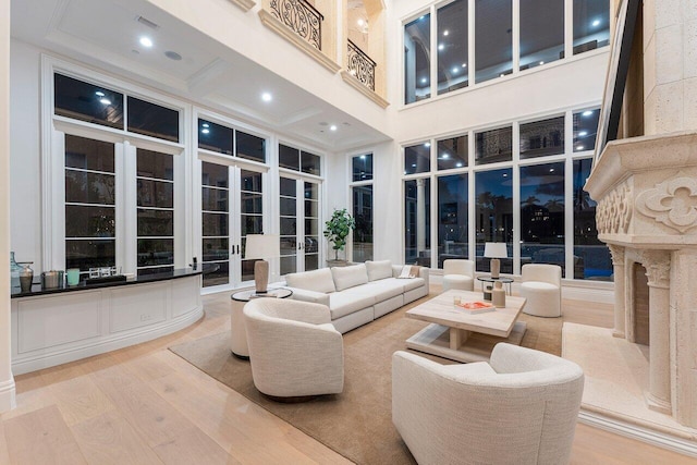 living room with hardwood / wood-style floors, a high ceiling, and french doors