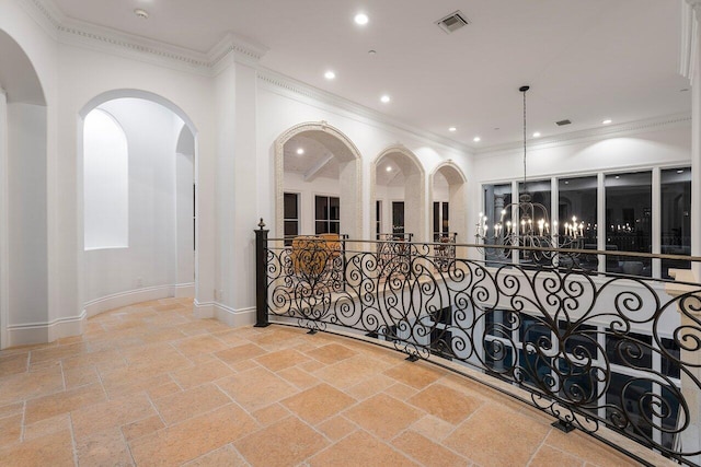 corridor with crown molding and an inviting chandelier