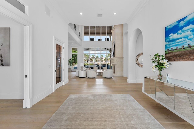 entrance foyer featuring crown molding, french doors, a high ceiling, and light hardwood / wood-style flooring