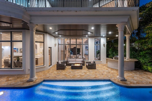 view of pool featuring outdoor lounge area, an outdoor kitchen, and a patio