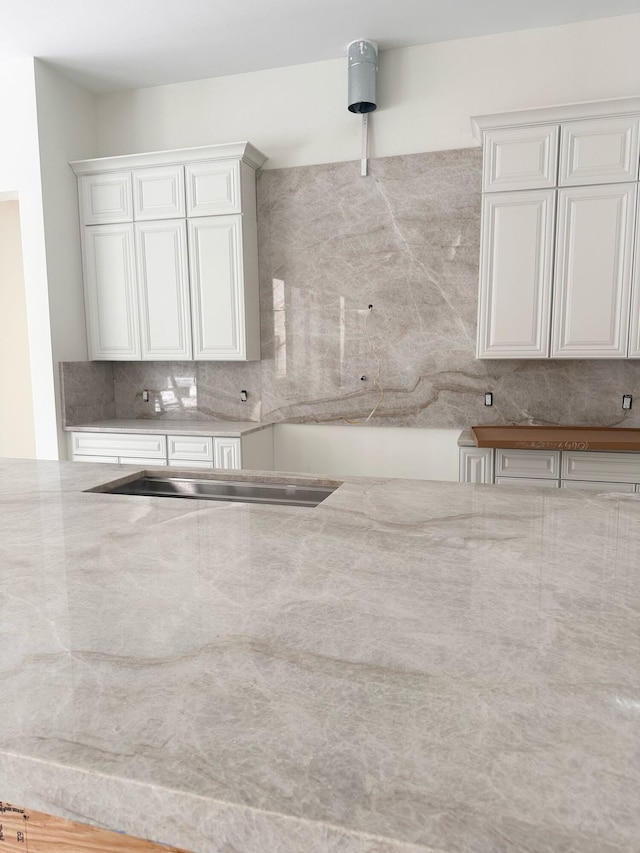 12850 152nd St N, Jupiter, FL 33478 - kitchen with decorative backsplash, light stone countertops, and white cabinetry