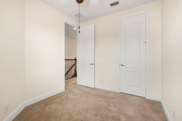 unfurnished bedroom with light carpet and ceiling fan