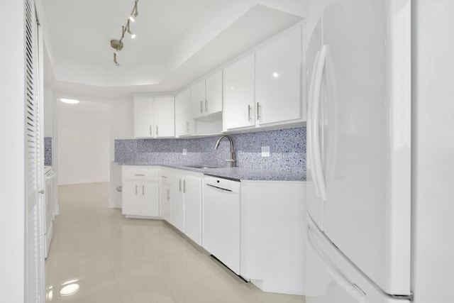 kitchen with white cabinets, sink, white appliances, tasteful backsplash, and light stone countertops