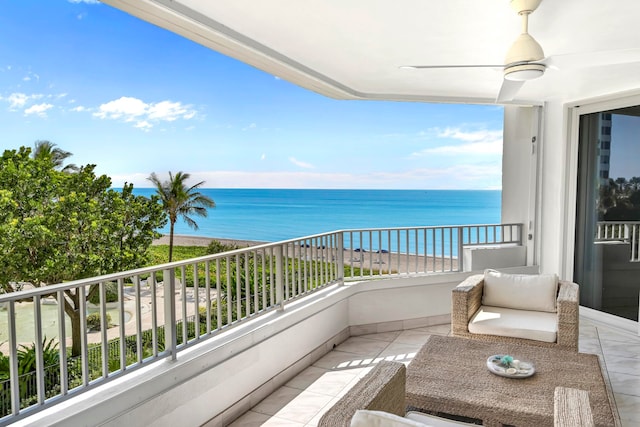 balcony with ceiling fan and a water view