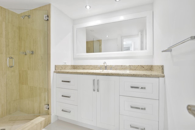 bathroom featuring vanity and a shower with door