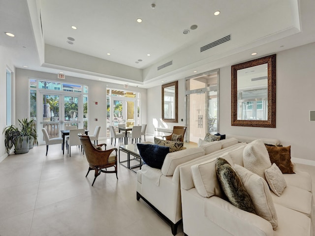 living room with french doors and a tray ceiling