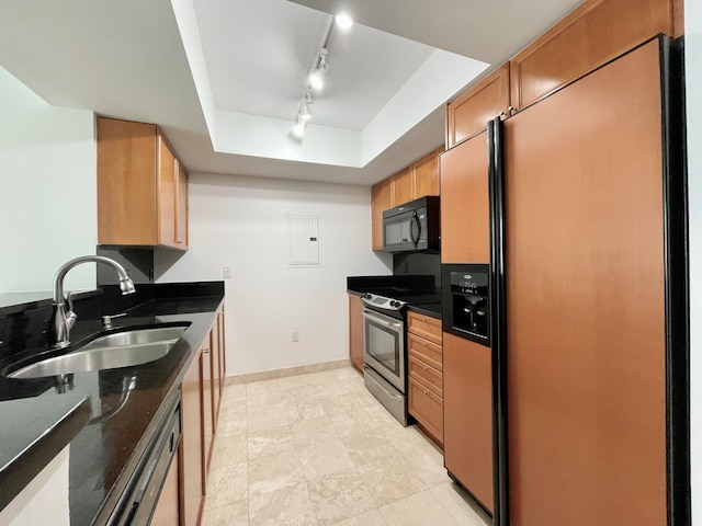 kitchen with built in refrigerator, track lighting, sink, a tray ceiling, and stainless steel electric stove