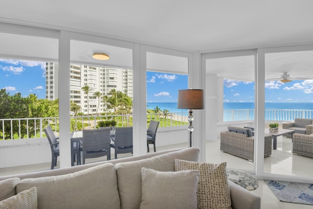 sunroom featuring a view of the beach and a water view