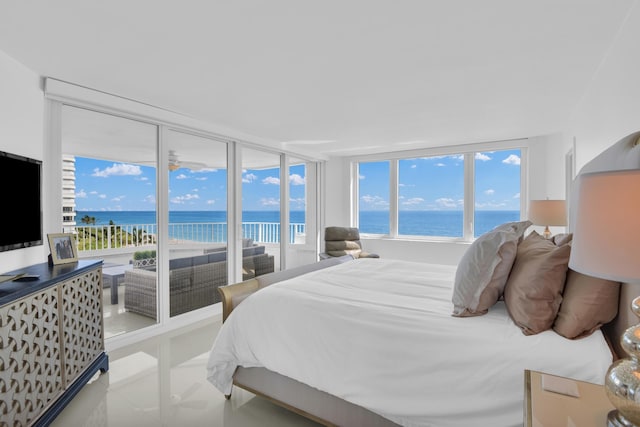 bedroom with light tile patterned floors, floor to ceiling windows, access to exterior, and a water view