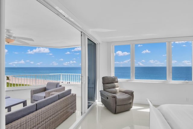 interior space featuring a view of the beach, a water view, and ceiling fan