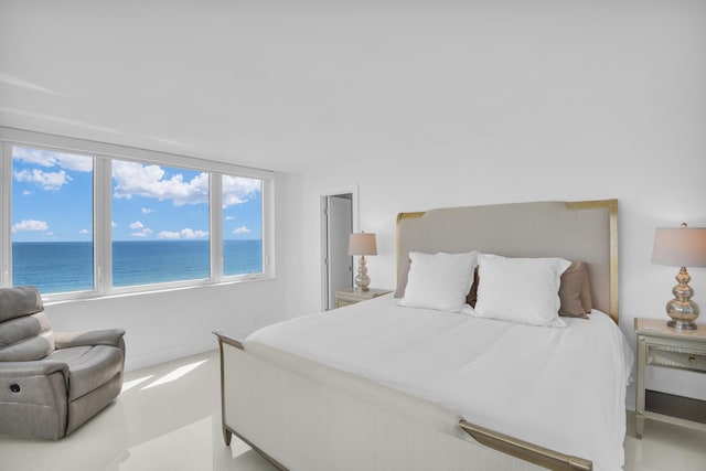 tiled bedroom featuring a view of the beach and a water view