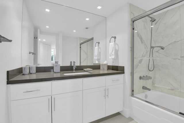 bathroom with bath / shower combo with glass door and vanity