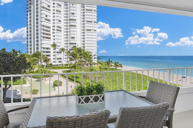 balcony with a water view and a view of the beach