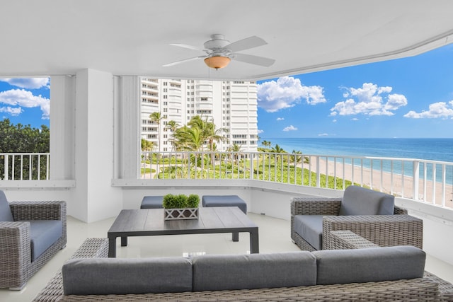 balcony with a view of the beach, a water view, ceiling fan, and outdoor lounge area