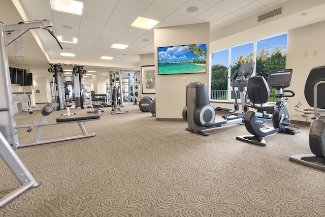 gym with light carpet and a drop ceiling