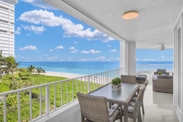 balcony with a water view, a beach view, outdoor lounge area, and ceiling fan