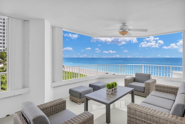 balcony with a water view, a beach view, ceiling fan, and an outdoor hangout area