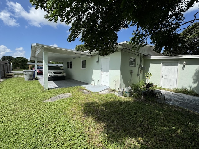 rear view of house with a carport and a yard