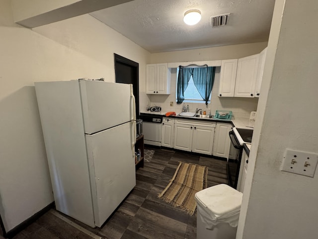 kitchen featuring dark wood-type flooring, sink, white cabinets, and white appliances