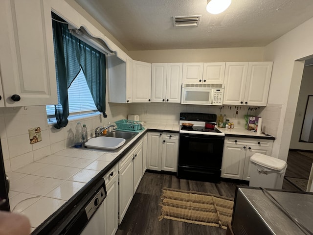 kitchen featuring sink, white appliances, white cabinets, dark hardwood / wood-style flooring, and tile countertops