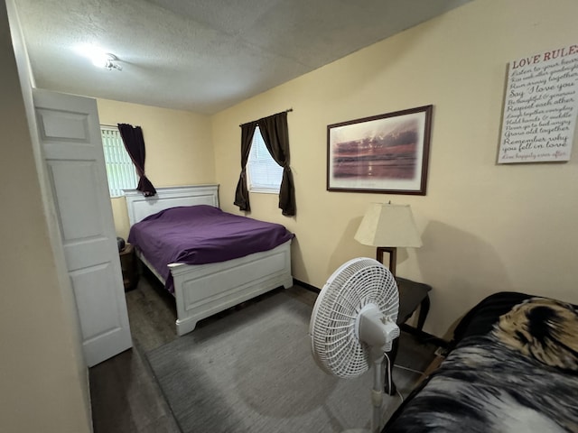 bedroom with dark wood-type flooring and a textured ceiling