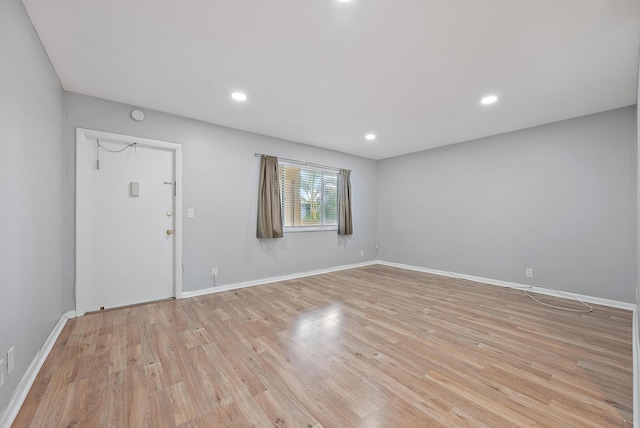 unfurnished living room with recessed lighting, light wood-style flooring, and baseboards