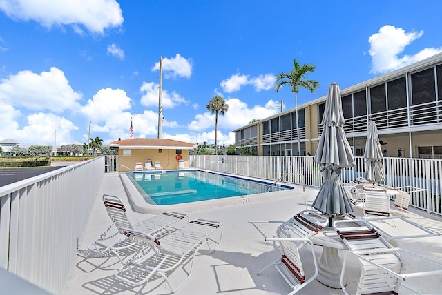 pool featuring fence and a patio area