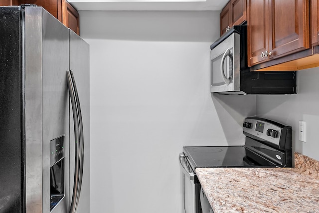 kitchen featuring stainless steel appliances and light stone counters