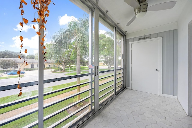 unfurnished sunroom with a ceiling fan