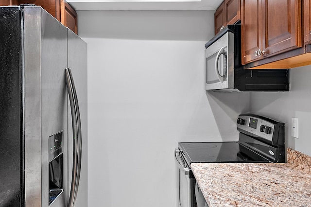 kitchen with brown cabinets and appliances with stainless steel finishes