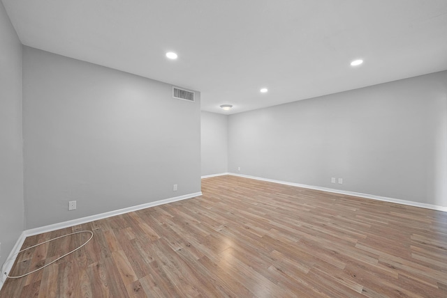 unfurnished room with light wood finished floors, recessed lighting, visible vents, and baseboards