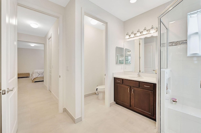 bathroom featuring tiled shower, vanity, toilet, and tile patterned floors