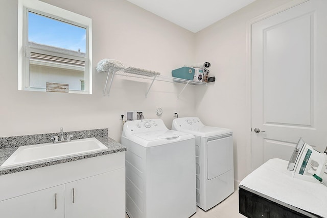 washroom with sink, independent washer and dryer, and cabinets