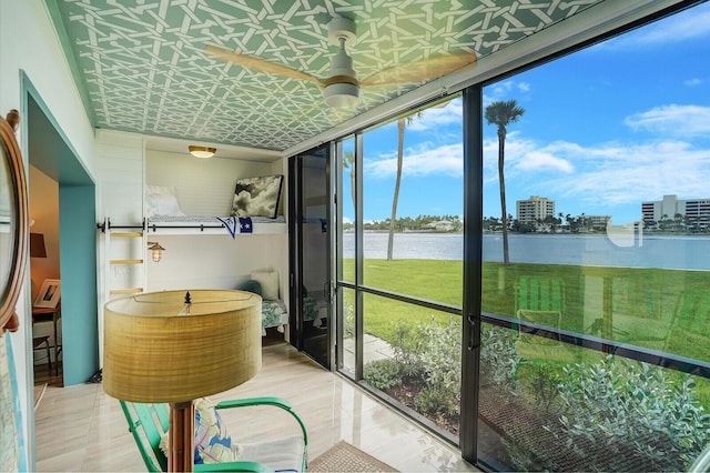 sunroom featuring a water view