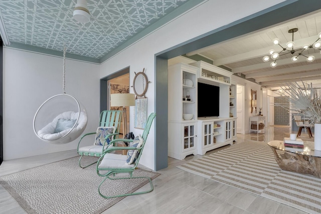 sitting room with beam ceiling, wooden ceiling, and an inviting chandelier