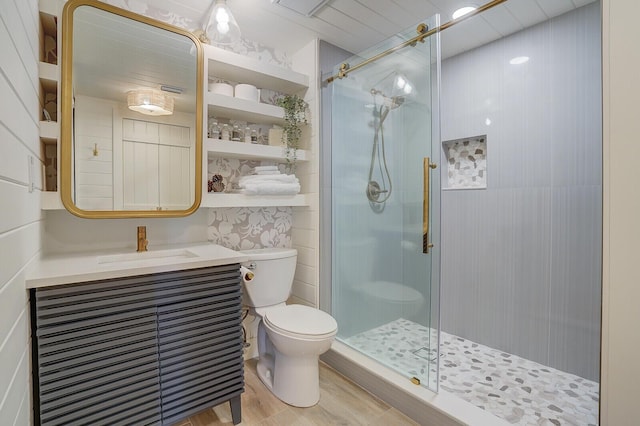 full bathroom with toilet, a stall shower, wood finished floors, and vanity