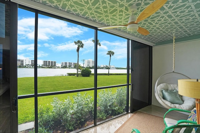 sunroom / solarium with a water view and ceiling fan