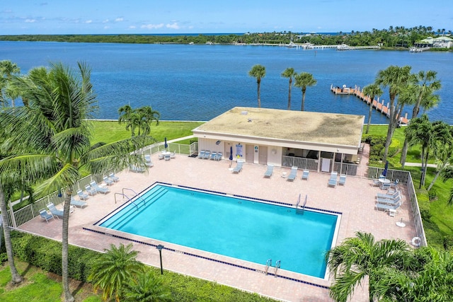 community pool featuring a water view, a patio area, and fence