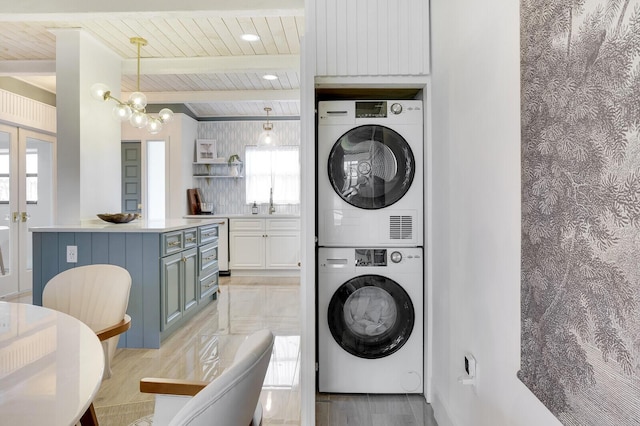 laundry room with wooden ceiling, stacked washer and dryer, laundry area, and a notable chandelier