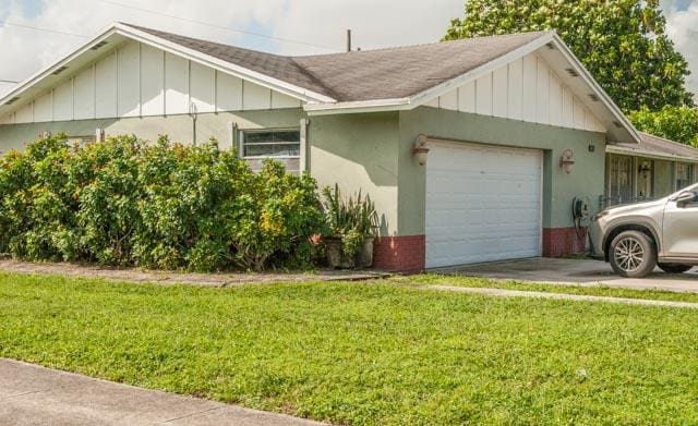 view of side of home featuring a lawn and a garage