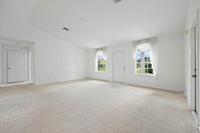 carpeted spare room with high vaulted ceiling and a chandelier