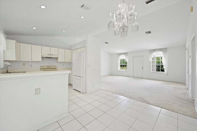 kitchen with vaulted ceiling, white cabinetry, white appliances, light tile patterned floors, and sink