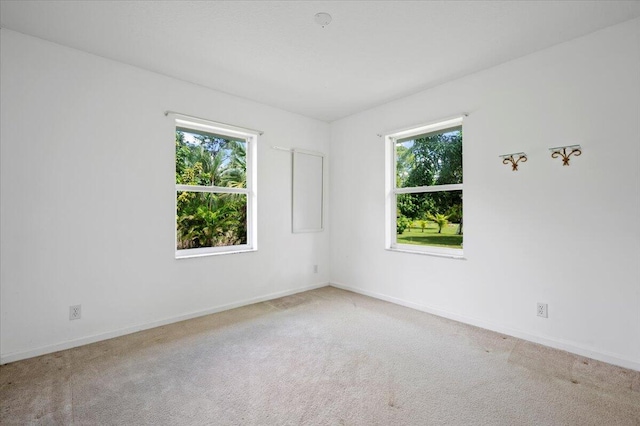 carpeted spare room featuring plenty of natural light