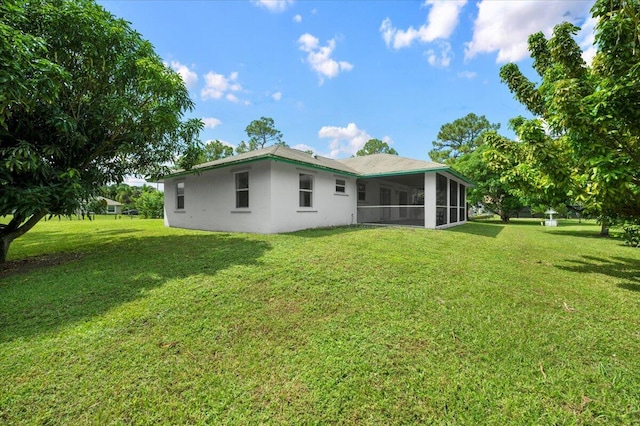 back of property with a yard and a sunroom