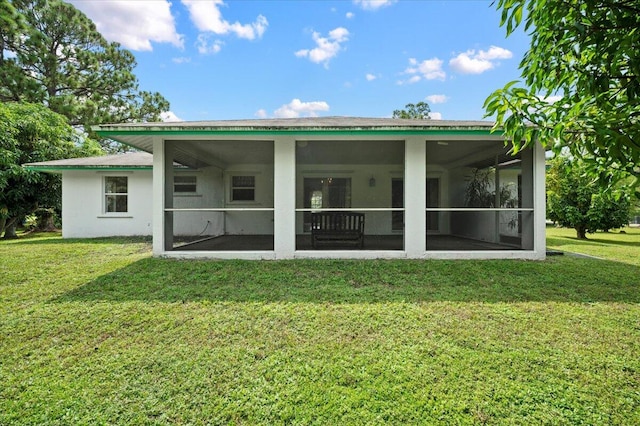 back of property with a sunroom, ceiling fan, and a yard